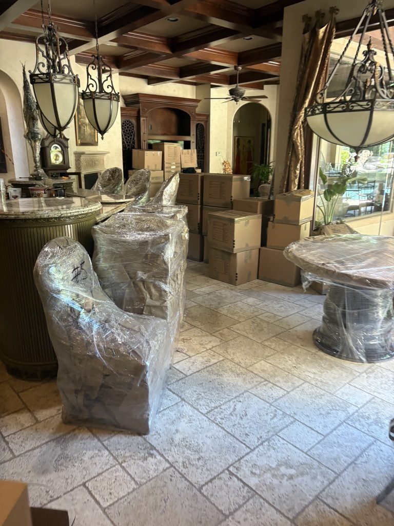 Wrapped furniture and labeled boxes staged in an upscale Houston home during a Tera estate cleanout